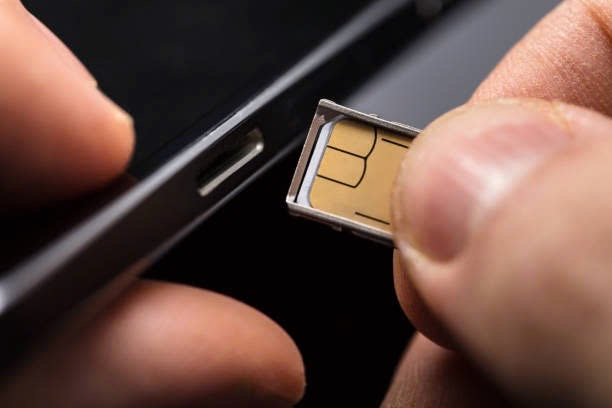 A hand inserting a SIM card into a phone